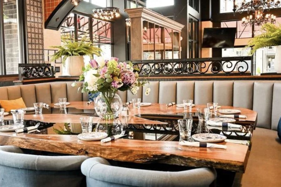 Dining room at Agave Cocina & Tequilas Queen Anne with a live-edge table, banquette seating and fresh flowers